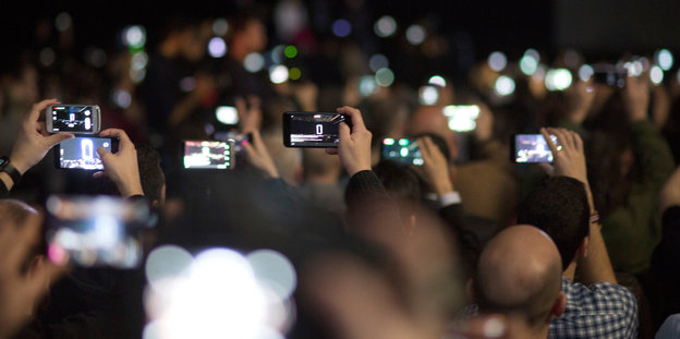 Zuschauer fotografieren mit ihren Smartphones