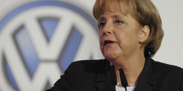 Angela Merkel spricht vor einem großen VW Zeichen auf einer Veranstaltung des Autokonzern