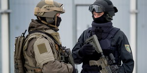 ein Bundeswehrsoldat und ein Polizist in schwerer Ausrüstung