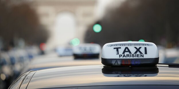 Taxischild auf einem Autodach in Paris
