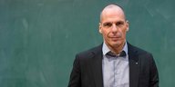 Yanis Varoufakis steht am Pult in einem Hörsal. Hinter ihm ist eine leere Schiefertafel.
