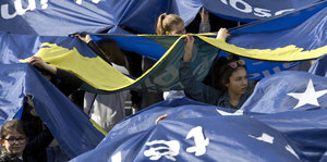 Menschen halten blaue Banner in die Luft