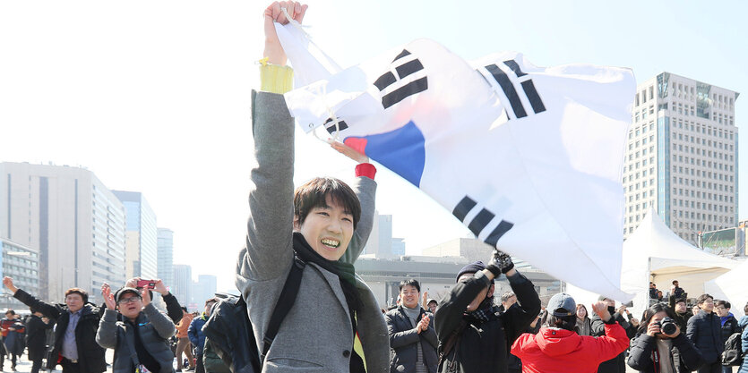 Junger Mann winkt mit Südkoreas Flagge