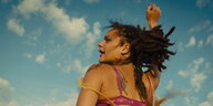 Szene aus "American Honey": Eine Frau ist von hinten zu sehen, wie sie eine Faust in die Luft streckt