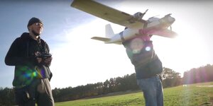 Zwei Männer starten eine Drohne, die wie ein kleines Flugzeug aussieht