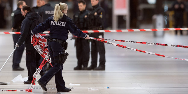 Eine Polizistin sammelt Absperrband nach dem Angriff in Düsseldorfer Hbf ein
