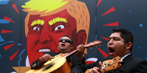 Musiker vor einem Wandbild von Donald Trump
