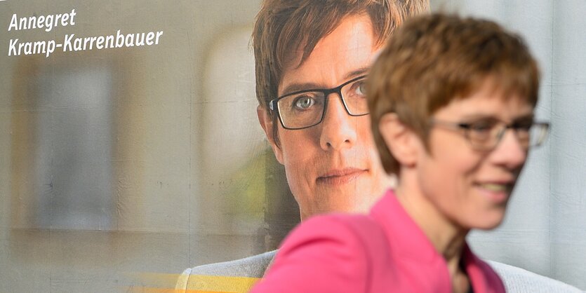 Eine Frau vor einem Wahlplakat. Es ist Annegret Kramp-Karrenbauer