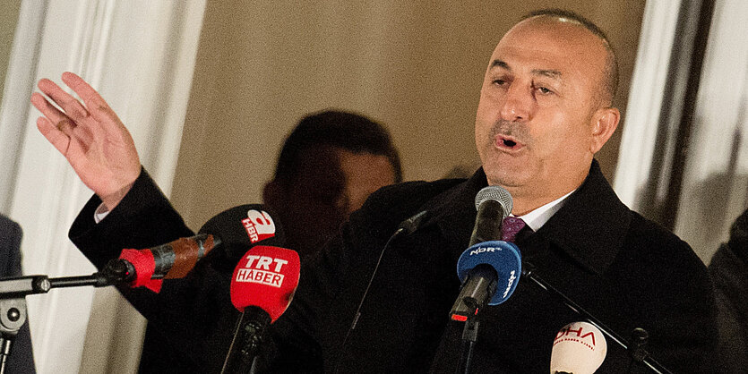 Mevlüt Cavusoglu spricht gestenreich in mehrere Mikrofone