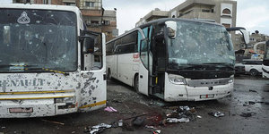 Mehrere stark beschädigte Busse auf einem Parkplatz