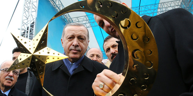 Erdogan begutacthtet ein vergoldetes Halbmond-mit-Stern-Objekt