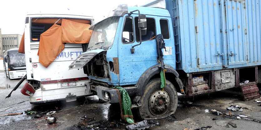 ein stark beschädigter LKW und ein ebenso stark beschädigter Bus