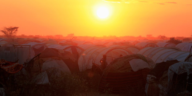 Sonnenuntergang über einem Lager, in dem die Zelte eng gedrängt stehen
