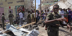Ein Polizist riegelt eine Straße in Mogadischu ab, in der ein Selbstmordattentäter sich in seinem Auto in die Luft gesprengt hat