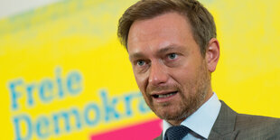 FDP-Chef Christian Lindner von einer gelben Wand mit der Aufschrift 