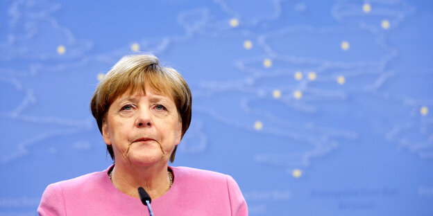Angela Merkel steht vor einer Europakarte
