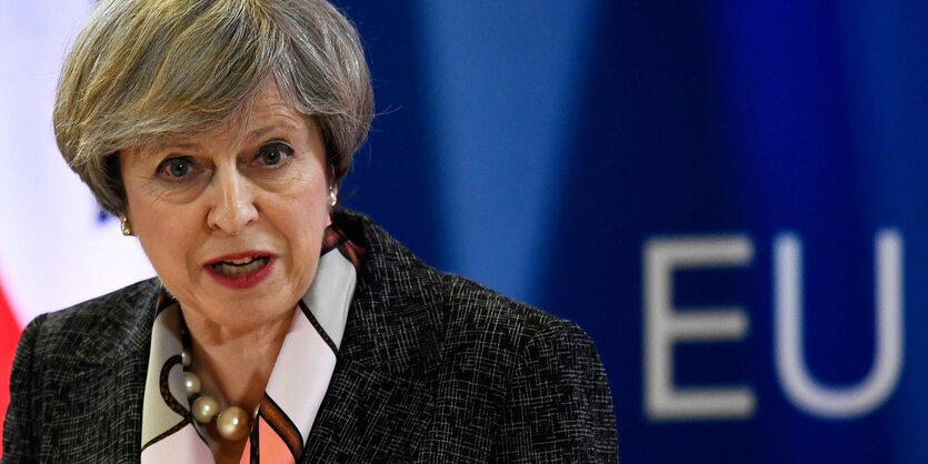 Theresa May redet vor einer Fahne der EU