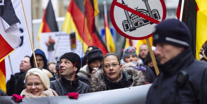 Rechte Demonstranten mit Anti-Islam-Schildern vor Polizisten