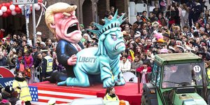 Karnevals-Trump-Figur penetriert knieende Freiheitsstatue