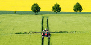 Ein Tracktor verteilt Pestizid auf einem Feld