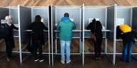 Fünf Menschen in Wahlkabinen