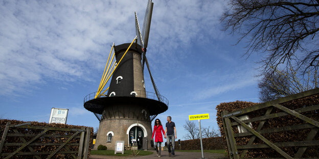 Zwei Leute vor einer Windmühle