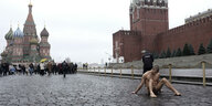 Ein nackter Mann sitzt auf dem Roten Platz in Moskau