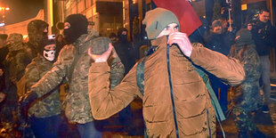 Ein Demonstrant hält einen Stein in der Hand