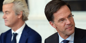 Geert Wilders und Mark Rutte sitzen nebeneinander. Rutte schaut von Wilders weg