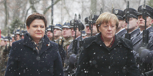 Merkel und Polens Premierministerin Szydlo schreiten bei Schneefall eine Ehrengarde ab