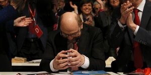 Martin Schulz sitzt mit gesenktem Haupt und aneinander gelegten Fingerspitzen da