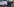 Männer in schwarzen Uniformen und Gesichtsmasken stehen am offenen Kofferraum eines Polizeiwagens
