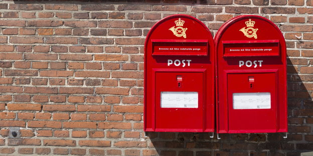 zwei rote Briefkästen an einer Klinkerwand