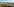 Eine kahle, sandige Landschaft, im Hintergrund rauchen Schornsteine