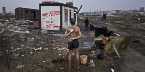Ein 14-jähriger Flüchtling duscht zwischen Müll in Belgrad
