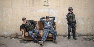 Irakische Polizisten ruhen sich am 19.03.2017 in Mossul (Irak) während der Gefechte zwischen irakischen Sicherheitskräften und Kämpfern der Terrormiliz Islamischer Staat auf einem Sofa aus.