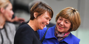 Zwei Frauen mit kurzen Haaren unterhalten sich und lachen