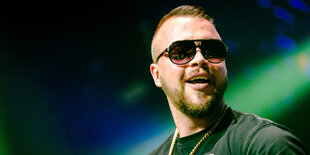 Rapper Kollegah trägt eine Sonnenbrille und eine Kette um den Hals