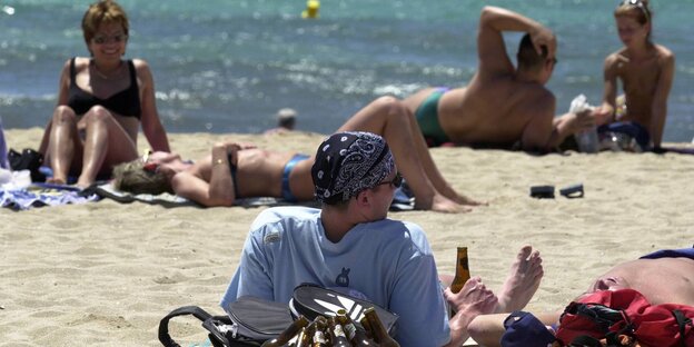 Nordeuropäerische Touristen mit Bier am Strand von Mallorca