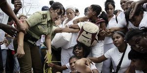 Eine Gruppe von weiß gekleideten Frauen kämpft gegen Polizistinnen