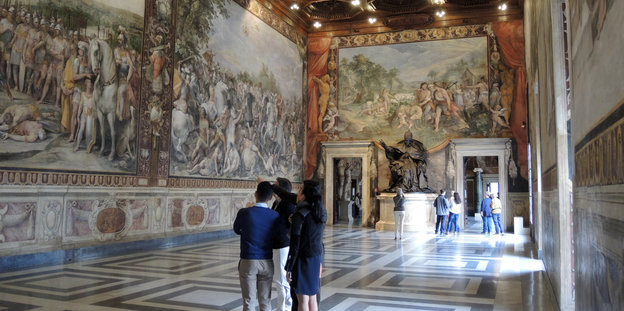 Ein großer, breiter Gang mit Gemälden an den Wänden