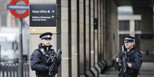 Zwei Polizeibeamte sichern das Areal vor einem U-Bahnhof in Westminster