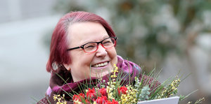 Natascha Wodin lächelt, vor ihr ein Strauß Blumen