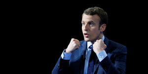 Porträt Emmanuel Macron mit erhobenen Fäusten