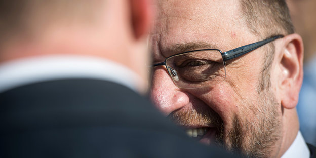 Martin Schulz strahlt jemanden an, sein Gesicht ist jedoch halb hinter dieser Person verborgen