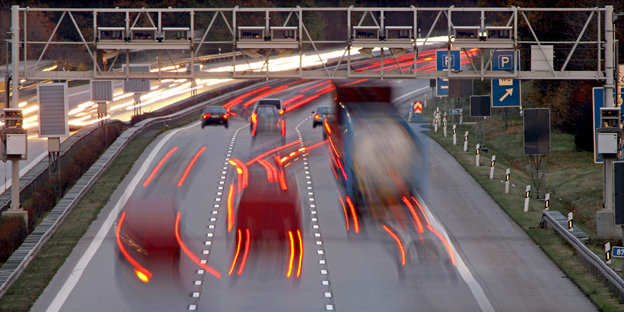 Autos fahren auf einer Autobahn unter einem Metallgestänge