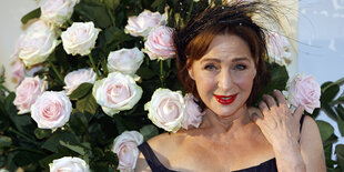 Eine Frau steht vor Rosen