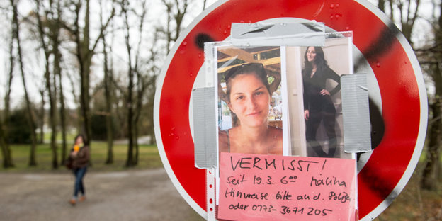 Auf einem Straßenschild hängt ein Bild der vermissten Studentin Malina und ein Zettel mit der Aufschrift "Vermisst! Hinweise bitte an die Polizei!"