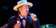 Bob Dylan mit Hut auf dem Kopf und Mikro in der Hand