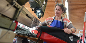 Eine Frau arbeitet an industrieller Nietmaschine